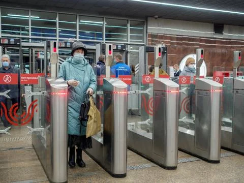 Passengers pass through automatic turnstiles at the Moscow metro station. Stock Photos