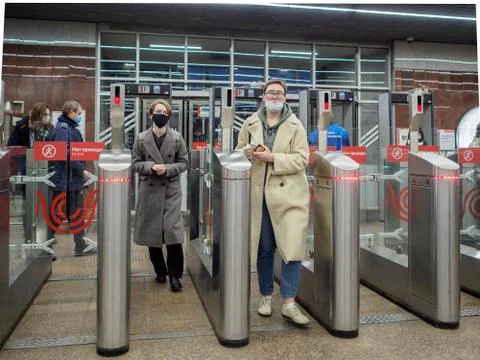Passengers pass through automatic turnstiles at the Moscow metro station. Stock Photos