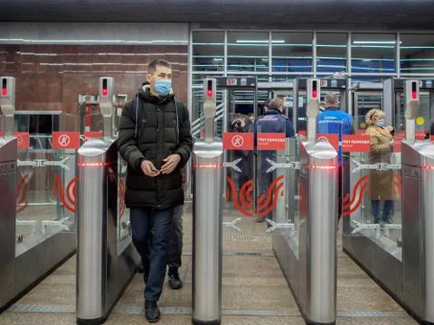 Passengers pass through automatic turnstiles at the Moscow metro station. Stock Photos