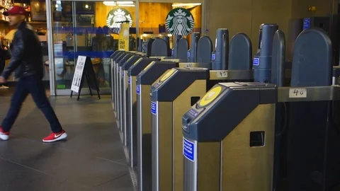 Passengers pass through contactless ticket barriers to enter and exit Wood La Stock Footage 106214667