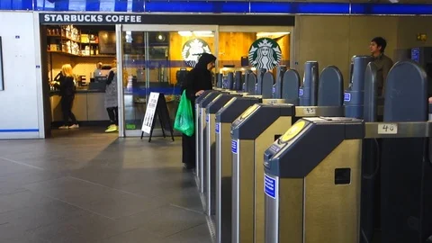 Passengers pass through contactless ticket barriers to enter and exit Wood La Stock Footage 106216471