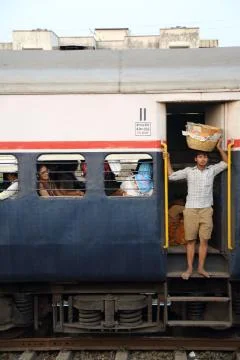 Passengers on a passing train in India. Foto stock