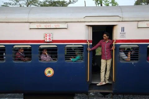 Passengers on a passing train in India. Стоковые фото