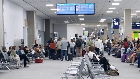 Passengers patiently queue and sit near departure gate within Galeao Rio de Stock Footage 105509067