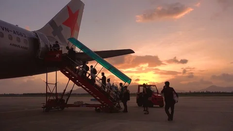 The passengers prepare to board the plane in the sunset Stock Footage 83271832
