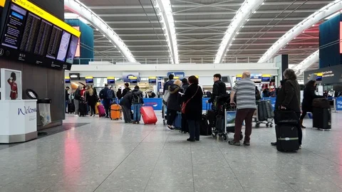 Passengers queue for check in at Heathrow International Airport in London, UK Video stock 104781793