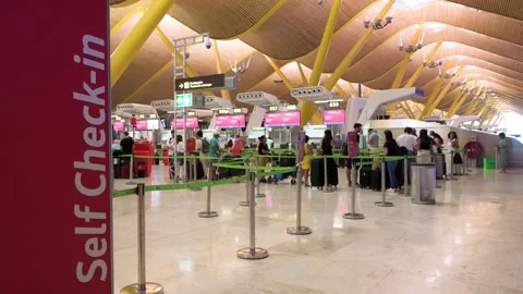 Passengers queue at Iberia desks with self-check-in machines at Madrid-Barajas Stock Footage 305224661