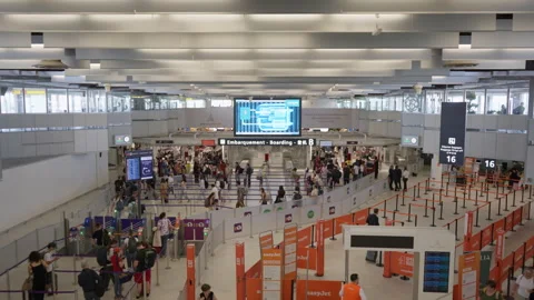 Passengers queue inside a busy airport terminal hall before boarding a flight Video stock 336725851