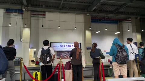 Passengers queue with luggage at BNI City railway station in Jakarta. Stock-Footage 334377315