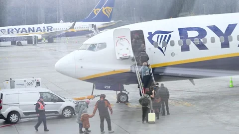 Passengers Queue on a Wet Tarmac to Board a Low-Cost Ryanair Commercial Stock Footage 314644157