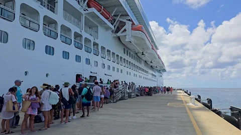 Passengers queued along the dock beside Carnival Mardi Gras at Grand Turk Stock Footage 328642303
