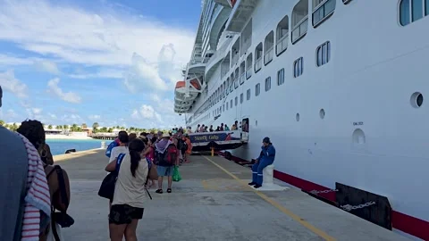 Passengers queued at Dock End beside Carnival Mardi Gras at Grand Turk Turks Video stock 328624815