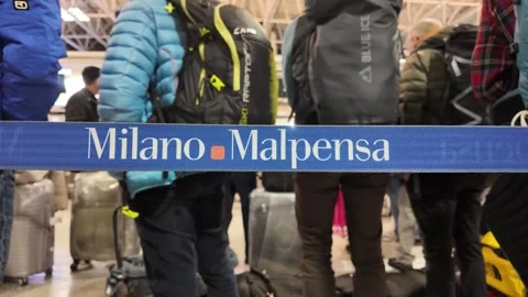 Passengers queueing at milan malpensa airport check-in counter Stock Footage 333569815