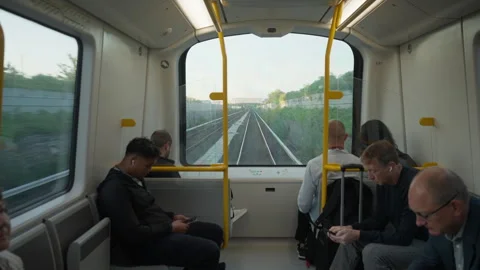 Passengers ride inside modern metro train car using smartphones during commute Stock Footage 344956543