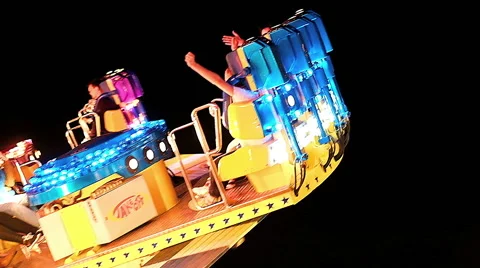 PASSENGERS SCREAMING IN FAST TURNING CAROUSEL AT NIGHT Stock Footage 52363853