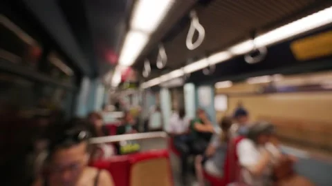 Passengers seated and standing inside a subway train, with visible handrails and 動画素材 335950069