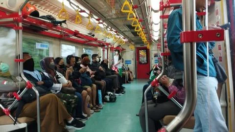 Passengers sit and stand on a crowded subway car Stock-Fotos