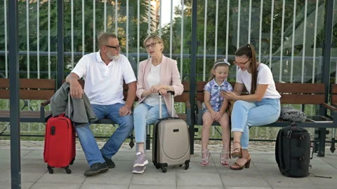 Passengers sitting on a bench waiting for a train at the station. Elderly Stock Footage 138104054