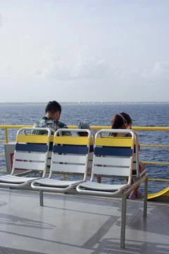 Passengers sitting in a ferry on the open deck Fotos de archivo