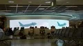 Passengers sitting in front of large LED video wall at airport Frankfurt 4k or 4k+ Resolution