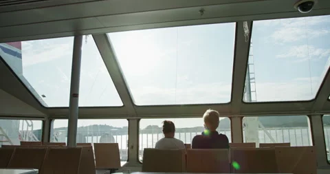 Passengers sitting inside ferry with panoramic windows and sunlit sea view Stock-Footage 317070496