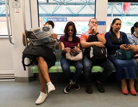 Passengers sitting inside a metro train while traveling on public transport Stock Photos
