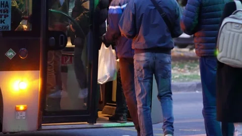 Passengers stand in line at transport stop to get on bus. People are in hurry Stock Footage 163682768