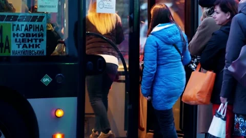 Passengers stand in line at transport stop to get on bus. People are in hurry Stock Footage 163683026