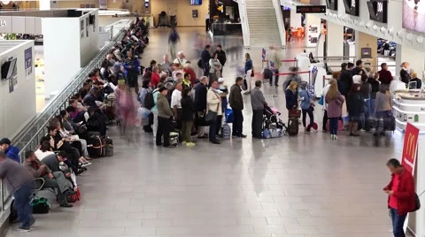 Passengers stand in queue to boarding gate, people rush around airport lounge Video stock 65783530