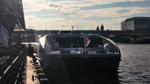 Passengers step on and off a moored Thames Clippers catamaran at London Bridge Stock Footage 341358184
