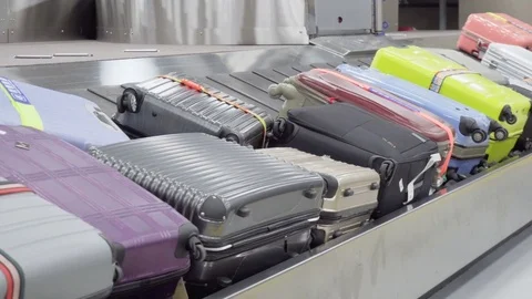 Passengers taking suitcases from moving conveyor belt Stock Footage 84794099