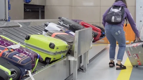 Passengers taking suitcases from moving conveyor belt Stock Footage 84800681