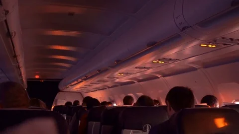 Passengers talking on board of an airplane at sunset Stock Footage 112141659