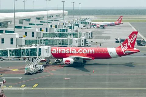 Passengers using jet bridge to boarding in airplane by AirAsia airline Stock Photos