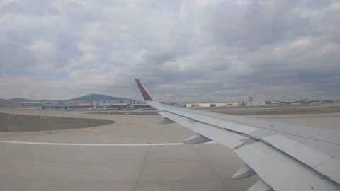 A passenger's view of an airplane wing while taxiing on the runway Stock Footage 305078858