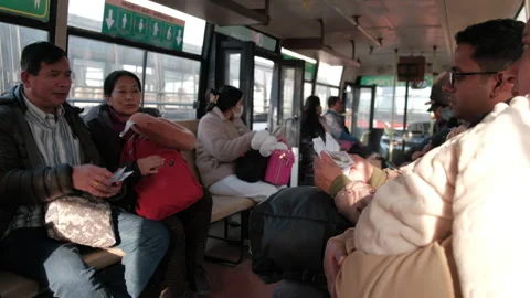 Passengers wait calmly in the airport shuttle bus while children rest on their Stock Footage 303579013