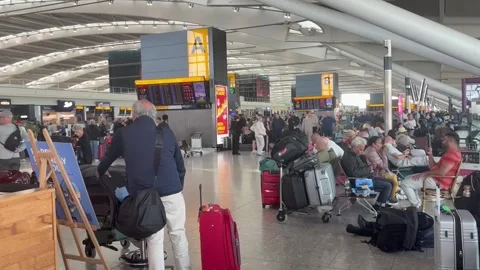 Passengers wait at Heathrow T5 for updates on their flights after Nats incident Stock Footage 345055503