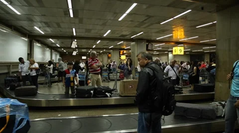 Passengers wait for luggages on the babbage belt at Guarulhos Airport Video stock 36691232