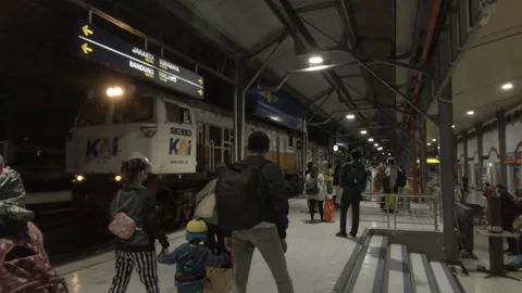 Passengers wait the train to stop at the Semarang Tawang Station at the night Stock Footage 152983431