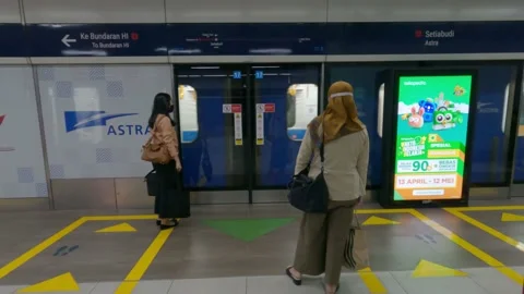 Passengers waiting the Jakarta MRT Train by wearing mask and physical distancing Stock Footage 153792355