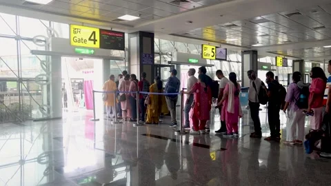 Passengers waiting in queue for boarding at airport gate with yellow signage Stock Footage 319052933