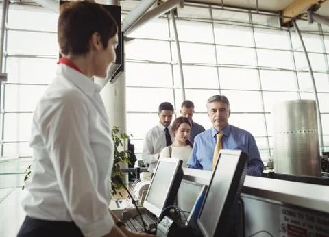 Passengers waiting in queue at check-in counter 스톡 사진