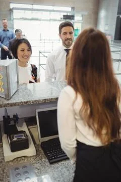 Passengers waiting in queue at check-in counter Stock Photos