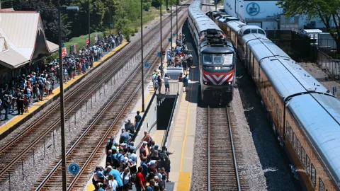 Passengers waiting at a railway station platform as a passenger train arrives Stock Footage 338320004