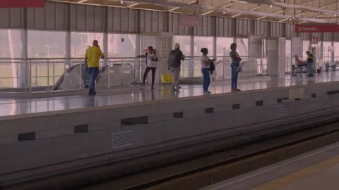 Passengers waiting for the train on an elevated metropolitan station platform  Stockbeeldmateriaal 338185382