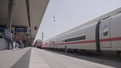 Passengers Waiting as Trains Arrive at Sunny Urban Railway Platform Stock Footage 334054949