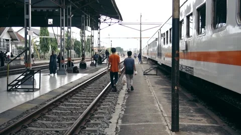 Passengers walk beside the train at kertosono station Stock Footage 231422414
