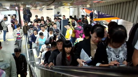 Passengers walk out of train and on to the escalator in a subway in Beijing Stock Footage 42380383