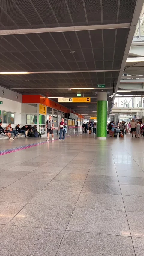 Passengers walk through a modern interior of Warsaw Chopin Airport in Poland.  Stock Footage 345253471