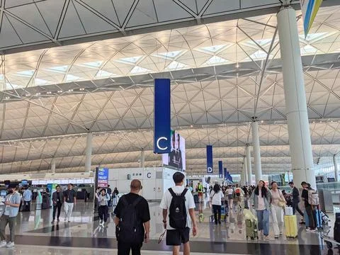 Passengers walking beneath the soaring, geometric roof of Hong Kong Stock Photos